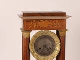 a clock that is sitting on top of a wooden stand