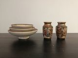 trois vases et un bol posés sur une table