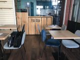 many tables and chairs in this small restaurant