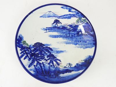 une assiette bleue et blanche ornée d'un paysage de montagne