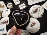 a person holding a black bowl with a green dot in it