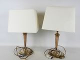 une paire de lampes de table en laiton avec des abat-jours blancs et des cordons