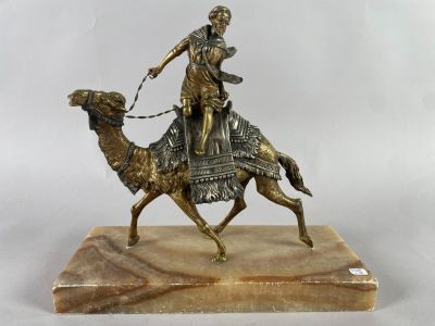 statue d'un homme à dos de chameau, posée sur un socle en marbre