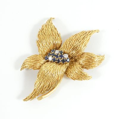yellow gold tone flower brooch with blue and white stones