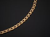 a gold necklace with a chain that is shaped like a heart