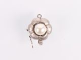a close up of a white pearl pendant on a white surface
