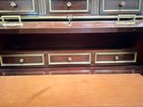 a brown bench sitting in front of a wooden cabinet