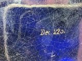a close up of a blue vase with writing on it