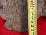 un mètre ruban sur un morceau de bois qui se trouve sur un tapis rouge