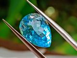 un gros plan sur un diamant bleu tenu par deux tweets