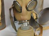 two old gas masks and a canister on the table