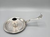a silver plate with a black stone on top of it