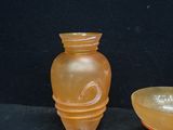 two vases sitting next to each other on a black surface