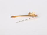 a close up of a gold pin with a needle sticking out of it