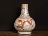 a vase with a dragon on it sitting on a table