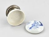 a white cup and a blue and white plate on a table
