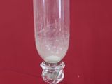 un vase en verre posé sur une nappe rouge, avec un fond rouge