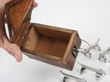 a person holding a small wooden box with tools in it