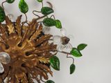 a gold and green wall sconce with leaves on it