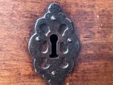 a metal keyhole on a wooden cabinet door