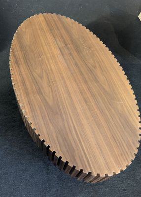 a close up of a wooden cutting board on a black surface