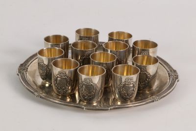 a silver tray with cups on it on a white table