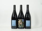 trois bouteilles de vin posées sur une table blanche