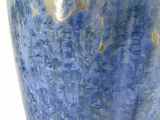 a large blue vase with a white base on a table