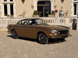 une voiture marron garée devant un immeuble
