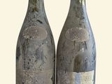 two bottles of wine sitting next to each other on a table