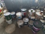 many buckets of paint sitting on the floor in a room