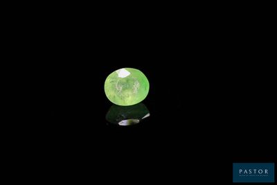 gros plan d'une pierre précieuse verte sur une surface noire