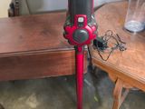 un aspirateur rouge et noir posé sur une table en bois