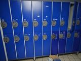 many blue lockers in a room with a washer and dryer