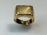gros plan d'une bague en or sur une surface blanche