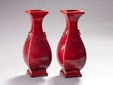 deux vases rouges posés l'un à côté de l'autre sur une table