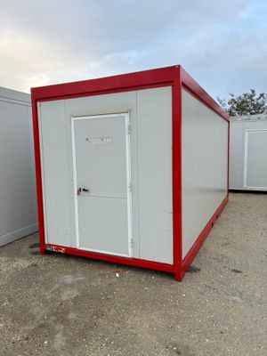 deux toilettes portables rouges et blanches dans un parking
