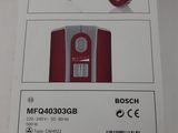 packaging of a red hand mixer in a box on a white surface