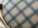 a blue and white checkered upholstered chair with wood legs
