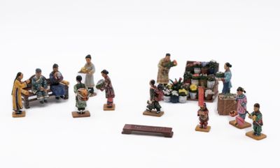 a group of figurines of people sitting on a bench