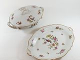 two plates with flowers and a bird on them on a white surface