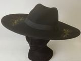 a black hat with a black band on top of a mannequin head