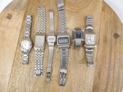 de nombreuses montres posées sur une planche en bois posée sur une table