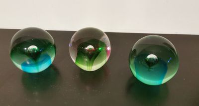 three glass marbles sitting on top of a table next to each other