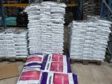 many bags of cement sitting on pallets in a warehouse