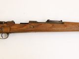 un vieux fusil en bois accroché au mur d'une pièce