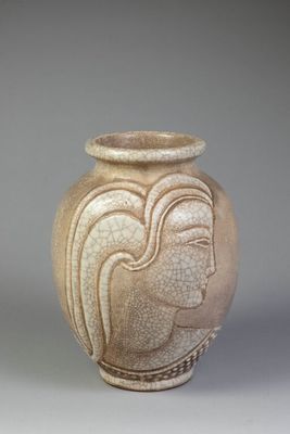 a vase with a face on it sitting on a table