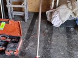 un balai posé par terre à côté d'une boîte à outils