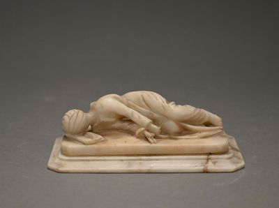 carved ivory figurine of a woman lying on a marble base