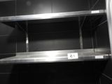 une étagère en métal sur laquelle est accrochée une pancarte, dans des toilettes